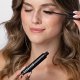 Eine Frau trägt sorgfältig Mascara auf, um ihre Wimpern zu betonen, und konzentriert sich dabei intensiv auf ihre Make-up-Routine.