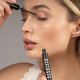 Das Model schaut nach unten und trägt die Wimpernspülung Nanolash auf